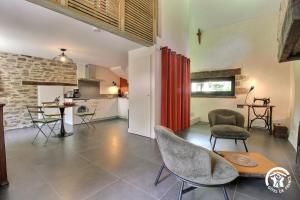 a kitchen and a living room with a table and chairs at Les hortensias in Sulniac