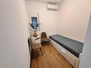 a small room with a bed and two chairs at Luna Blue Ada in Donji Štoj