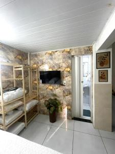 a bedroom with two bunk beds and a television at Kit net morro de são Paulo in Cairu