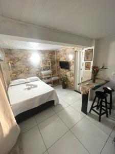 ein Hotelzimmer mit einem Bett und einem Badezimmer in der Unterkunft Kit net morro de são Paulo in Cayru