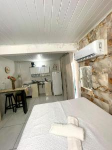 Zimmer mit einer Küche und einem Bett in einem Zimmer in der Unterkunft Kit net morro de são Paulo in Cayru