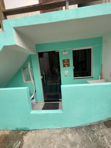 ein blaues Gebäude mit einem Fenster darin in der Unterkunft Kit net morro de são Paulo in Cayru