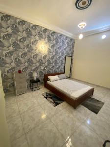 a bedroom with a bed and a wall at Loft K&G in Cotonou