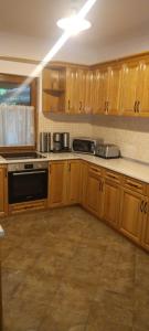 a kitchen with wooden cabinets and a stove top oven at Fenyves Home in Izvoare +21 photos