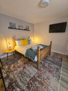 a bedroom with a bed and a tv on the wall at Abbey Lodge - Room 2 in Ardara +4 photos