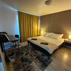 a bedroom with a large bed and a piano at SO Easy Stay, Malmö in Malmö