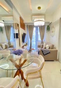 a living room with a glass table and chairs at Luxe Living in Iloilo City