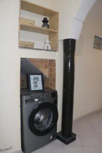 a washing machine in a room with a fireplace at Appartement Imi-Ouaddar 2 in Imi Ouaddar