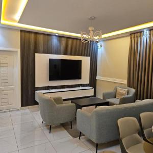 アクラにあるM&L APARTMENT HOMEsのソファと薄型テレビのあるリビングルーム