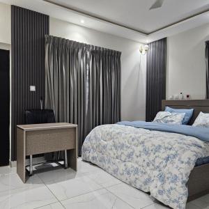 アクラにあるM&L APARTMENT HOMEsのベッドと机とカーテンのある寝室