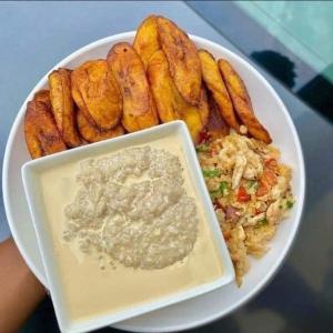 a plate of food with a bowl of dip and french fries at Cbox Lodge & Lounge in Lagos
