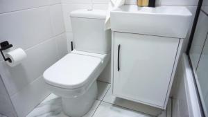 Un baño blanco con inodoro y lavabo. en ADAIA GUEST Apartments, en Johannesburgo