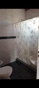 baño con aseo y cortina de ducha con mariposas en Nuevo Aire, en Santa Rosa del Conlara