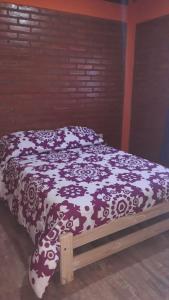 1 cama con edredón marrón y blanco en Nuevo Aire, en Santa Rosa del Conlara