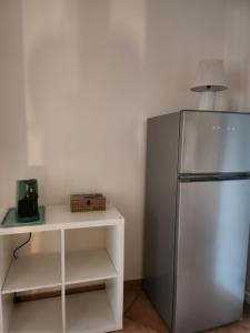 a kitchen with a refrigerator and a table with a lamp at Villetta Magnolia in Giardini Naxos