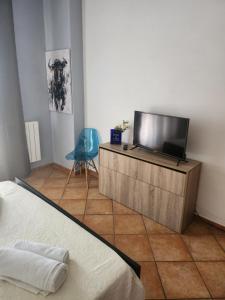a bedroom with a tv on a wooden dresser at Villetta Magnolia in Giardini Naxos