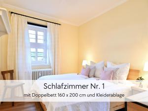 una camera da letto con un letto bianco e una finestra di GRÄFIN AMALIA - Apartment in der historischen Hinterburg Schlitz - 2 Schlafzimmer - mit Aufzug, Parkplatz, E-Ladestation & Garten - nahe Fulda und Bad Hersfeld a Schlitz
