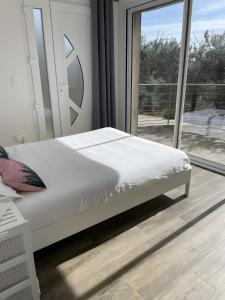 a white bed in a room with a window at Villa Luxe – Vues panoramiques in Volx