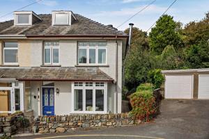 a house with a blue door and a stone wall at 3 Bed in Harlech oc-g33093 in Harlech