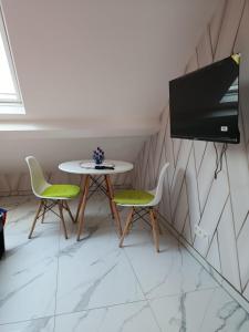 une pièce avec une table et deux chaises et une télévision dans l'établissement Le petit Tagidor - 5 suites - 2 kitchens - 5 bathrooms, à Charleroi