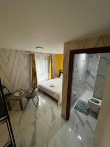 une chambre avec un lit et une salle de bain avec WC dans l'établissement Le petit Tagidor - 5 suites - 2 kitchens - 5 bathrooms, à Charleroi 13 autres photos