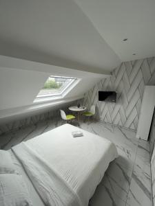 une chambre avec un lit, une fenêtre et une table dans l'établissement Le petit Tagidor - 5 suites - 2 kitchens - 5 bathrooms, à Charleroi