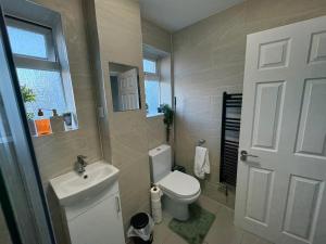 a bathroom with a white toilet and a sink at Modern & Spacious 3BR House Bracknell - Berkshire in Easthampstead +36 photos