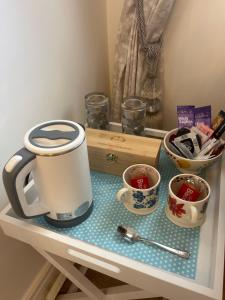 a table with a coffee maker and two cups on it at Boston Boutique Homestay King Bed Ensuite breakfast parking village location in Sibsey