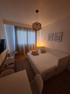 a bedroom with a large bed and a television at L'escapade Sweet home - vue sur Mer et Dragon de Calais in Calais