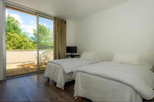 two beds in a white room with a window at Camping Domaine de Chaussy in Lagorce +36 photos