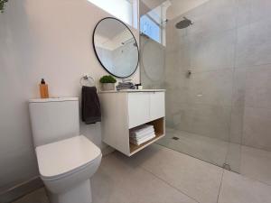 a bathroom with a white toilet and a mirror at The Ya Ya Apartment in Stellenbosch +51 photos