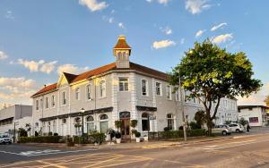 a large white building with a clock tower on a street at The Ya Ya Apartment in Stellenbosch