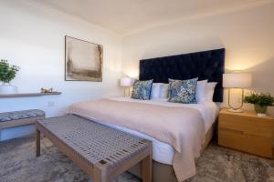 a bedroom with a large bed with a blue headboard at The Ya Ya Apartment in Stellenbosch