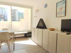 ein Wohnzimmer mit einem Tisch und einem TV auf einem Schrank in der Unterkunft Studio cosy au pied des pistes pour 4 personnes, balcon, cœur de station, proche activités - FR-1-292-185 in Isola