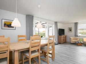 a dining room and living room with a table and chairs at Spacious Holiday Home On A Large Plot, With Space To Play in Ålbæk