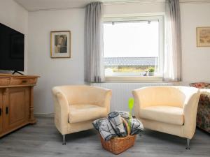 a living room with two chairs and a television at Spacious Holiday Home On A Large Plot, With Space To Play in Ålbæk +3 photos