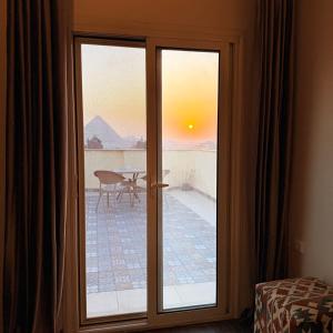a sliding glass door with a view of a patio at Five Pyramids Peaks View in Cairo