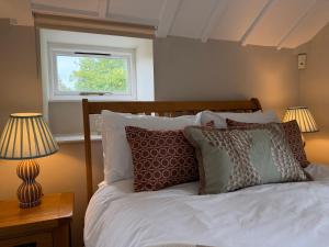 a bedroom with a bed with pillows and a window at North Lodge at Pudleston Court in Hatfield +24 photos