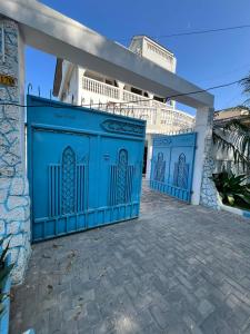 una recinzione blu di fronte a un edificio di ARRABELLA CAPETOWN STAY - Near Masaki a Dar es Salaam