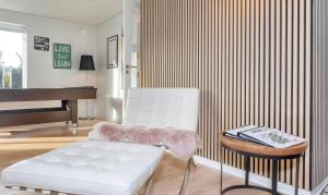 un soggiorno con sedia bianca e pianoforte di Holiday Home With Hot Tub And Offers Many Activities! a Debel