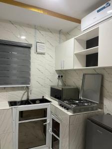 a small kitchen with a sink and a stove at DEVHAK Hotel and Suites in Warri