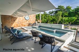 a swimming pool with chairs and a table and an umbrella at Pousada Bahia Inn in Morro de São Paulo +34 photos