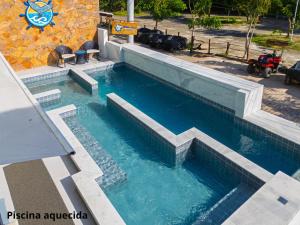 a large swimming pool with blue water in a building at Pousada Bahia Inn in Morro de São Paulo