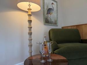 a table with a lamp and a bottle of champagne at North Lodge at Pudleston Court in Hatfield