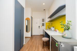 a kitchen with yellow and white walls and wooden floors at Sơn Trà Homestay in Da Nang +27 photos