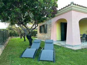 a group of blue chairs sitting in the grass at Exclusive Getaways by SardegnaSummer in San Teodoro