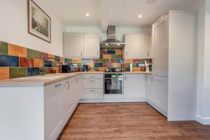 a kitchen with white cabinets and tiles on the wall at 2 Bed in Blandford St. Mary oc-s33308 in Charlton Marshall +9 photos