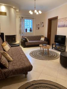 a living room with a couch and a table at Forest Breeze-1 - JM Rentals in Stení Dhírfios