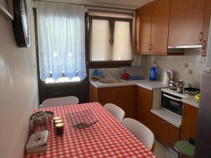 a kitchen with a red and white checkered table and chairs at Forest Breeze-1 - JM Rentals in Stení Dhírfios +14 photos