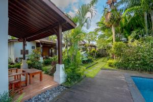 a house with a wooden deck next to a swimming pool at Pondok Sadia Villa in Tegalalang
